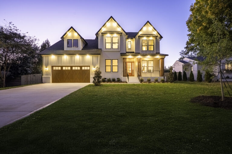 4724 Gilmore Dr — Two-story white exterior with twin front gables and a two-car garage, lit at twilight